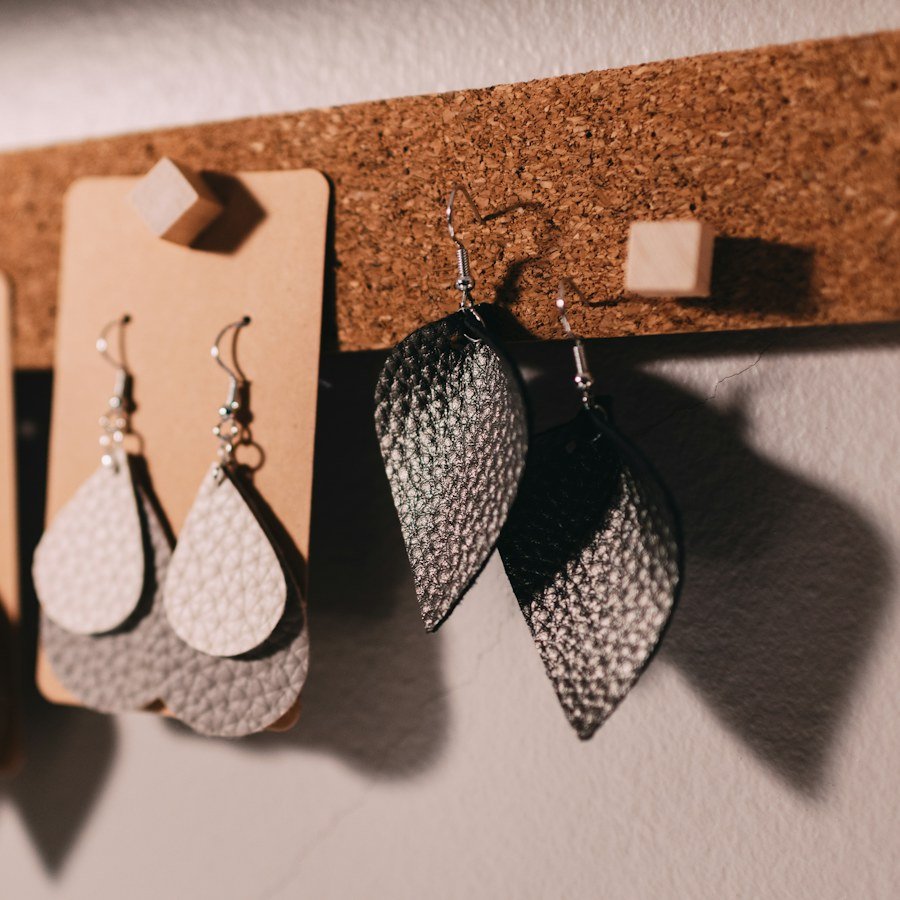 Boucles d’oreilles en cuir faites main, présentées sur un carton