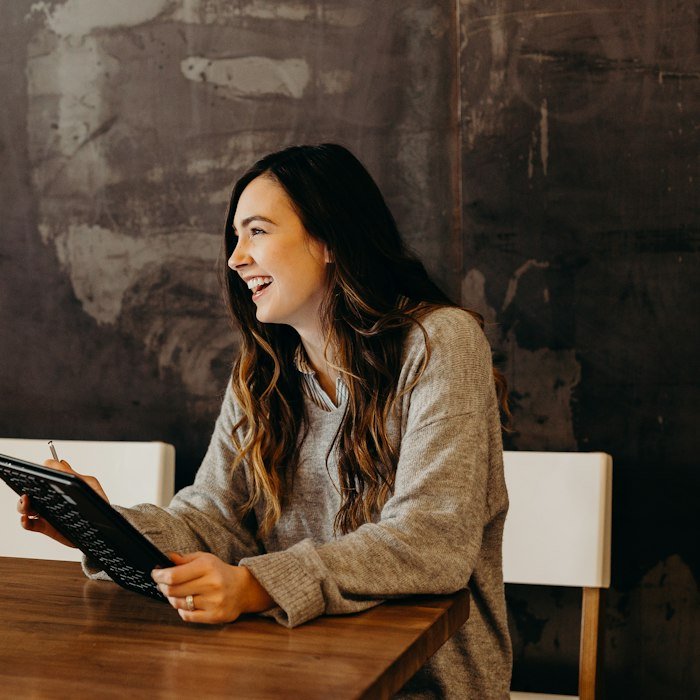 Une cliente souriante, sa tablette en main